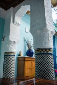 a white pillar with a blue vase on a table at Dar anne in Fez