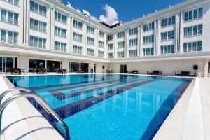 a large swimming pool in front of a building at Mercia Hotels & Resorts in Büyükçekmece