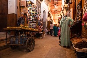 a man standing in a market with a cart at Dar anne in Fez
