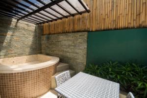 a bathroom with a bath tub and a table and a table and bench at Boracay Haven Suites in Boracay