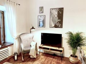 a living room with a television and a chair at Old Town Apartment-City Centre in Warsaw