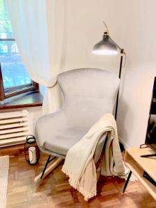 a blanket on a chair in a room with a lamp at Old Town Apartment-City Centre in Warsaw