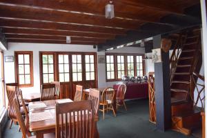 a dining room with tables and chairs and a staircase at Eco Creations Nuwaraeliya in Nuwara Eliya