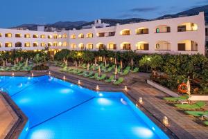 una imagen de un hotel con piscina y sillas en Hotel Malia Holidays en Mália
