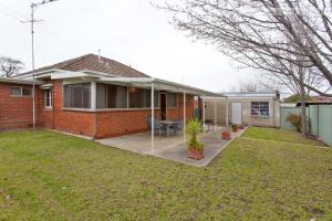 a red brick house with a patio in the yard at Red Brick Beauty - Central Cottage in Albury