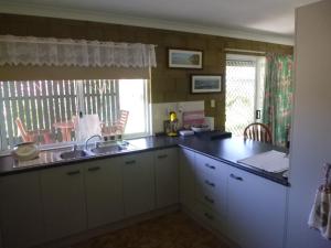 a kitchen with a counter and a sink and a window at dad & alice's place in Tin Can Bay