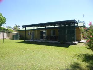 a house with a green yard in front of it at dad & alice's place in Tin Can Bay