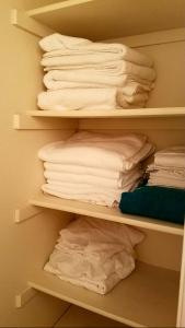 a closet with white shirts and towels on shelves at Lovely condo! Walking distance to the Strip with pool and spa in Las Vegas