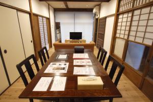 京都市松庵度假屋的用餐室配有桌椅和笔记本电脑
