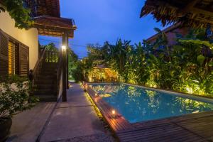una piscina en el patio trasero de una casa por la noche en Wat Bo House, en Siem Reap