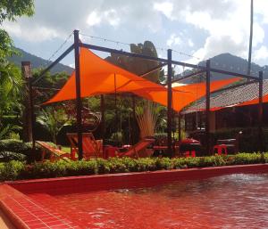 a restaurant with orange umbrellas next to a body of water at Harley Moon Hideaway in Ko Chang