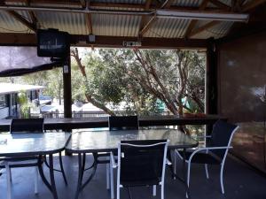 a group of tables and chairs on a patio at Coachman Motel in Toowoomba