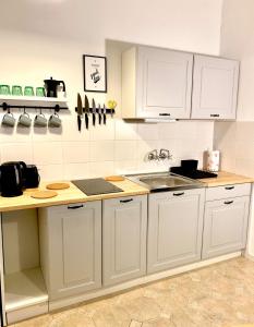 a kitchen with white cabinets and a sink at Old Town Apartment-City Centre in Warsaw