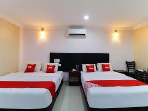 - 2 lits dans une chambre d'hôtel avec des oreillers rouges dans l'établissement OYO 89473 Sp Venture Hotel, à Rawang