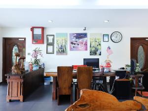 a room with a table and chairs and a clock at The Fern Lodge Hotel in Skudai