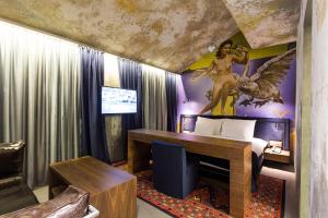 Schlafzimmer mit einem Bett mit Wandgemälde in der Unterkunft Hotel Hemera in Podgorica