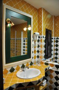 a bathroom with a sink and a mirror at Apartamentos Turisticos Doña Maria La Brava in Plasencia