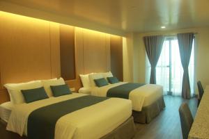 Tempat tidur dalam kamar di West Plaza Hotel at Lebuu Street