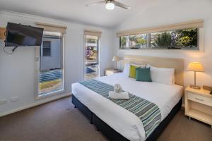 a bedroom with a bed with a tv and windows at Ingenia Holidays South West Rocks in South West Rocks
