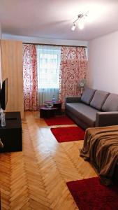 a living room with a couch and a large window at Very nice Apartment in L'viv in Lviv