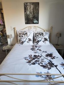 a bed with a white comforter with flowers on it at APPARTEMENT T2 AGROPARC AVIGNON in Avignon