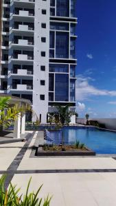 a building with a swimming pool in front of a building at Island Living at One Manchester Place in Mactan