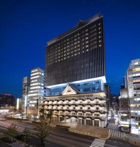 un grand bâtiment dans une ville la nuit dans l'établissement Hotel Royal Classic Osaka, à Osaka