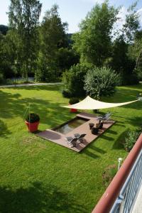 a backyard with a tent and chairs and a pond at AngerResidenz in Zwiesel