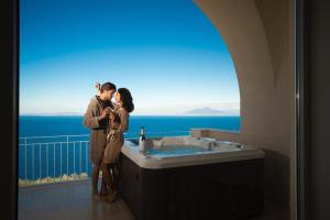 Una pareja de pie en un baño con bañera en Villa DAlessandro, en Anacapri