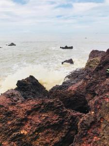 a view of the ocean with rocks in the water at Manshore bay in Kannur