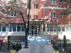 un bâtiment scolaire avec un drapeau devant lui dans l'établissement Apartman Karadjordje, à Zvezdara