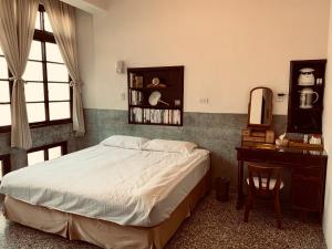 1 dormitorio con cama, escritorio y espejo en Shennong 147, en Tainan