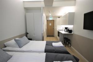 a hotel room with two beds and a kitchen at Forenom Aparthotel Varkaus in Varkaus