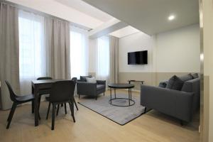 - un salon avec une table, des chaises et un canapé dans l'établissement Forenom Aparthotel Varkaus, à Varkaus