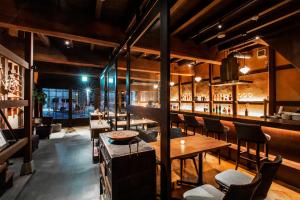 a restaurant with tables and chairs and a bar at Tomonoura Shiomachi Hotel in Fukuyama