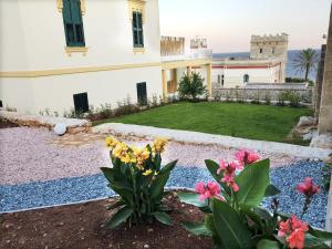un giardino fiorito di fronte a un edificio di Villa Cesarea Dimora di Charme a Santa Cesarea Terme