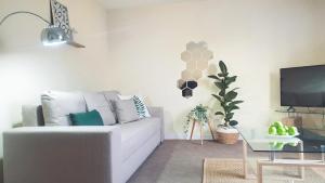 a living room with a white couch and a tv at Seymour Road - Parking for van - Contractors only in Oldbury