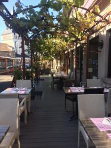 un restaurant avec des tables et des chaises sur un trottoir dans l'établissement Hotel Restaurant Cousseau, à Parentis-en-Born