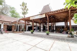 ein Gebäude mit einem Pavillon mit Bänken und Tischen in der Unterkunft Griya Erlangga Homestay in Yogyakarta