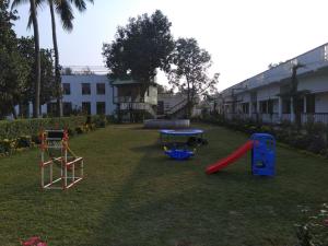 a playground with a slide and a table in a yard at Samriddhi Banquet Garden & Resorts in Baharampur