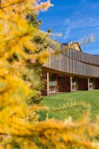 a large building with a roof on top of a field at Relais & Châteaux IN LAIN Hotel Cadonau in Brail