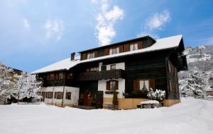 un gran edificio con nieve en el suelo en Haus Doro und Kurt en Schruns