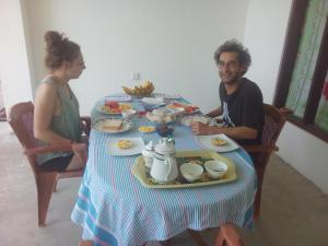 a man and woman sitting at a table with food at Daasa Guest Mirissa in Mirissa