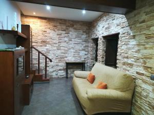 Vivienda de uso turístico, A Casa Do Campo في فيستيرا: غرفة معيشة مع أريكة وجدار حجري