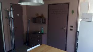 a kitchen with a refrigerator and a dresser next to a door at Studio lumineux centre ville in Luchon