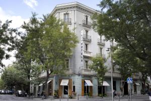 un edificio blanco con árboles delante de él en ICON Wipton, en Madrid