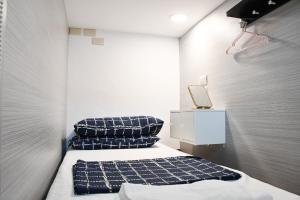 a small room with two beds and a night stand at 不倒翁輕旅可用優惠價預約機場碼頭接送 in Hsi-kuo-shan