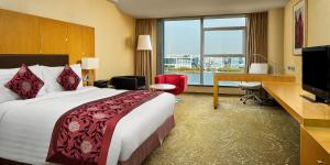 天津的住宿－天津濱海聖光皇冠假日酒店，酒店客房配有一张床、一张书桌和一台电脑