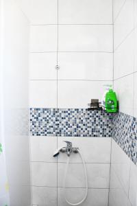 a shower with a hose in a bathroom at 不倒翁輕旅 in Hsi-kuo-shan