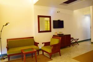 uma sala de estar com um sofá e uma televisão em Eighth Bastion Fort Kochi - CGH Earth em Cochin